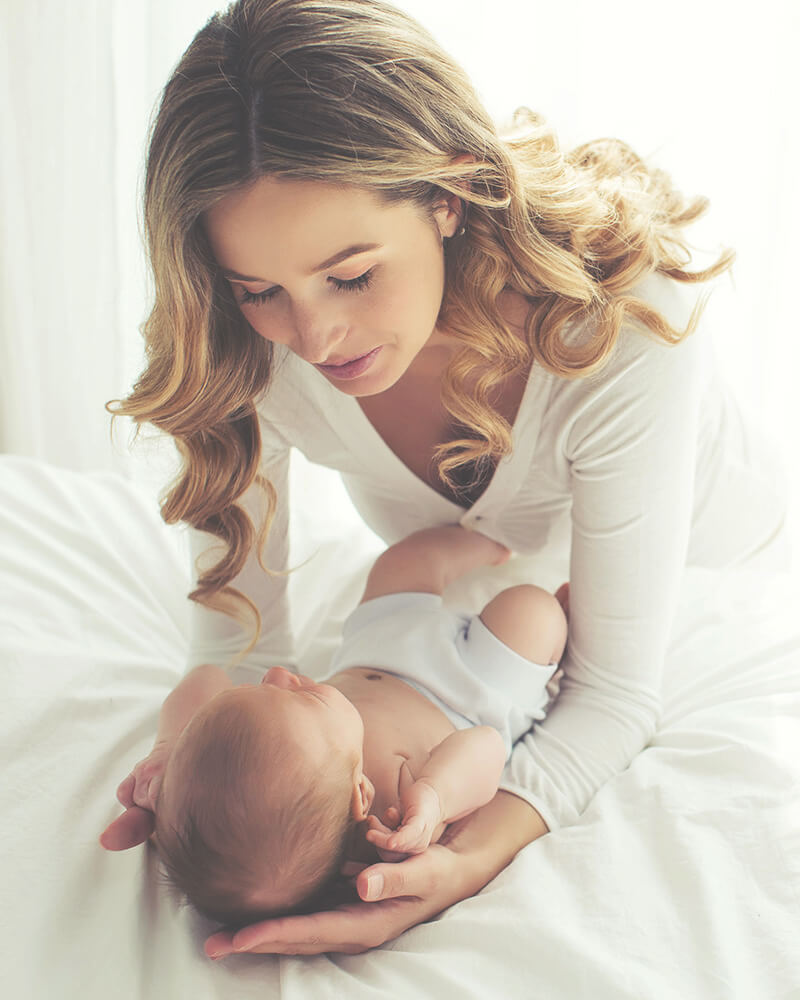 A woman looking over a baby